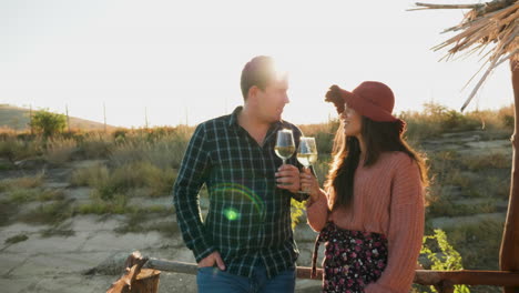 couple tasting wine on a pontoon in warm sunligh