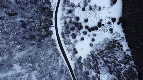 Aerial-view-of-a-winding-mountain-road-in-winter-covered-in-snow