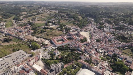 drone capturing alcobaça cityscape with the monastery at center, aerial circular pan shot