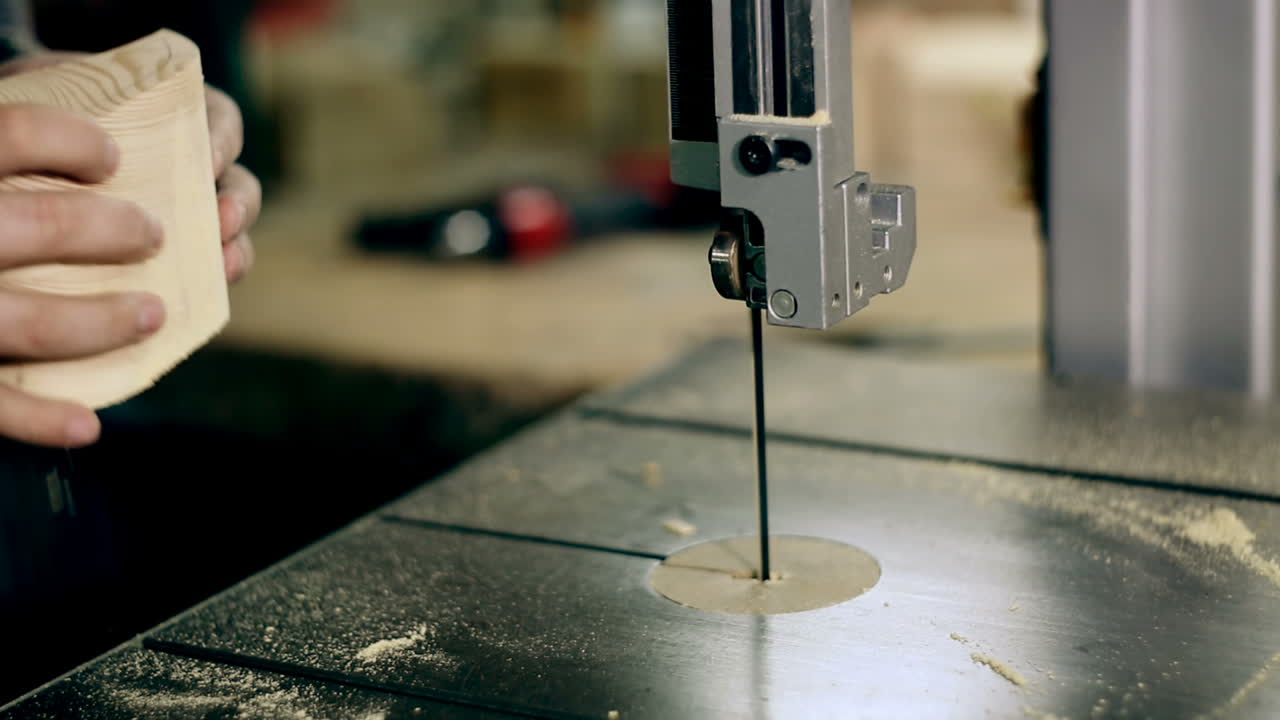 Man Uses An Electric Saw To Cut Wooden Planks. Carpenter is sawing a wooden plank with jig saw machine in carpentry workshop