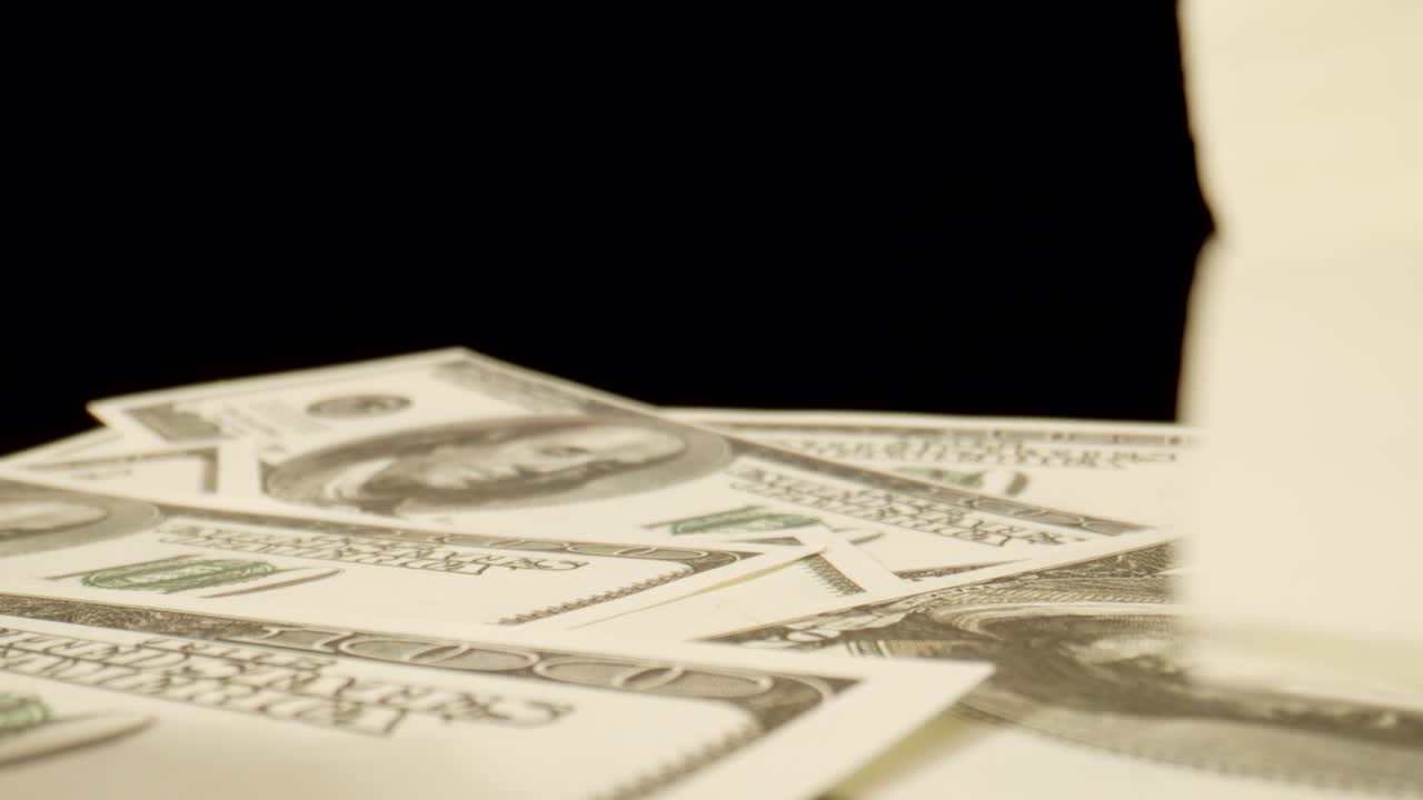 MACRO: Camera moves between stacks of US dollars on the table