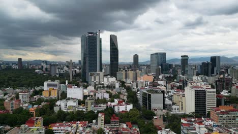 View-of-the-modern-skyscrapers-in-iconic-Paseo-de-La-Reforma-avenue-,-from-Colonia-Roma-in-Mexico-City,-Mexico,-cloudy-afternoon