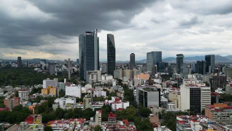 view of the modern skyscrapers in iconic paseo de la reforma avenue , from colonia roma in mexico city, mexico, cloudy afternoon
