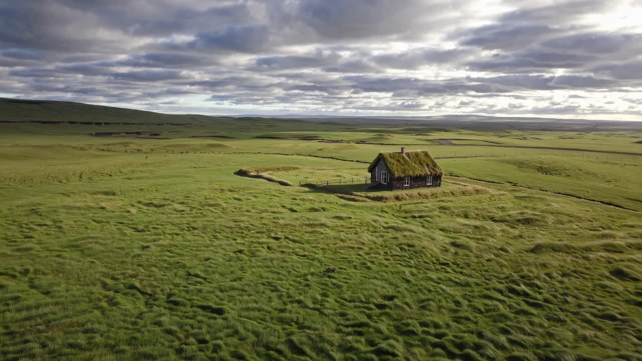 Lonely Icelandic house with grass covered roof nestled in verdant landscape, surrounded by moody clouded sky highlighting rural architectural charm