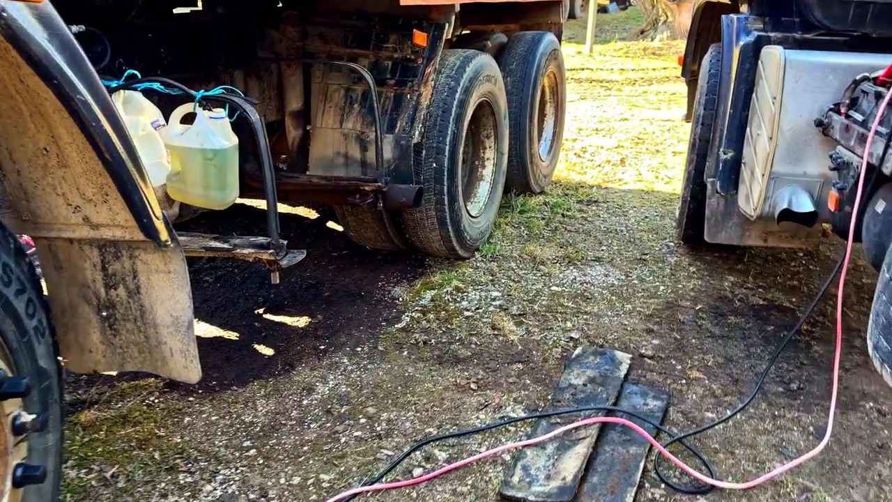 Emergency roadside assistance with two trucks jump starting and transferring diesel fuel