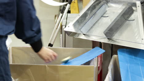 máquina automática de revestimiento de tapa dentro de un almacén de producción industrial de fabricación, primer plano de la mano de obra caucásica haciendo control de calidad prueba qc