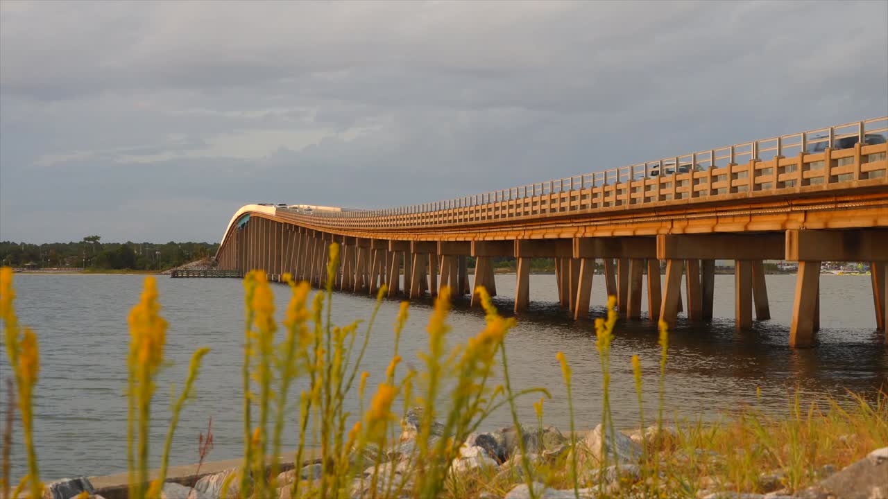 Dramatic shot of a Florida Bridge standing next to it on some rocks with beautiful sea oats