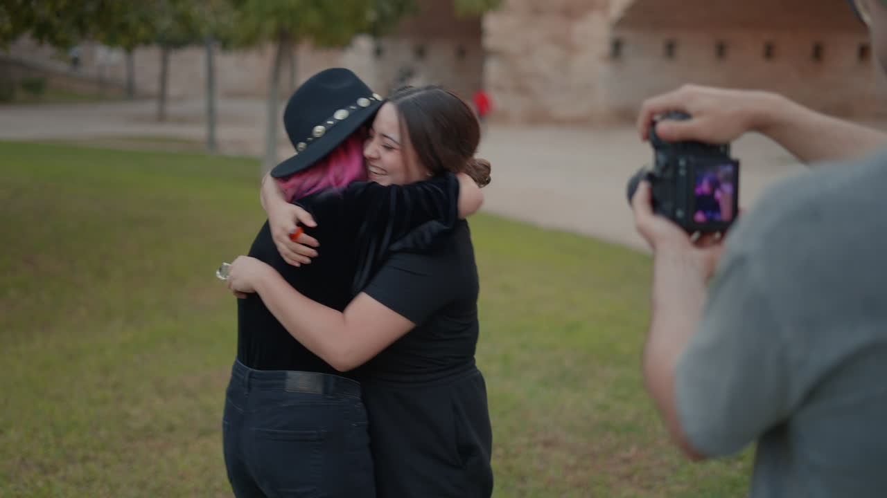 dos mujeres abrazadas en un parque.