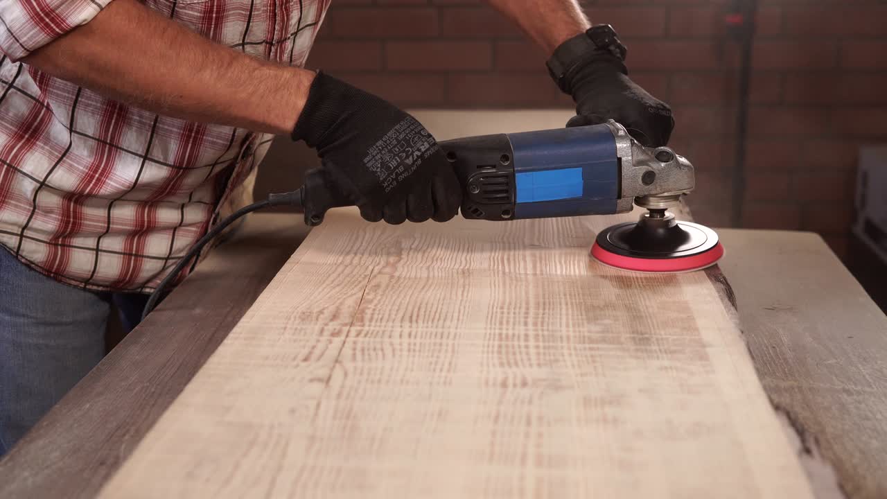 Cabinet maker is taking off upper layer of wood from billet on a factory