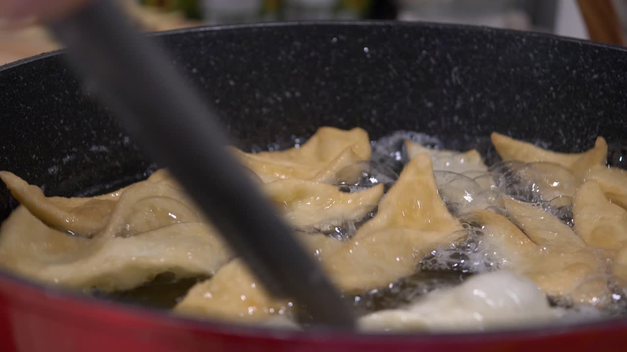 깊은 프라이팬에 기름을 두르고 엔젤윙을 굽고, 집게로 뒤집기