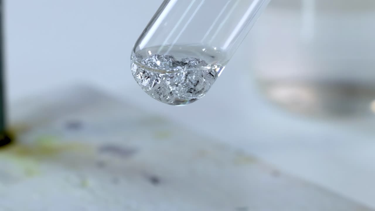 Detailed view of bubbles forming in a test tube during a chemical reaction.