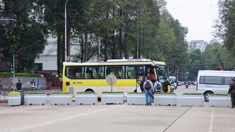 tourists boarding a yellow bus in hanoi