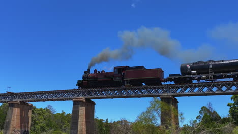 el tren de vapor southern downs steam railway que viaja sobre el puente rojo de stanthorpe, queensland.