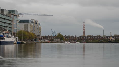 Zeitraffer-Des-Flusses-Liffey-Mit-Wohn--Und-Industriegebiet-Im-Hintergrund-Tagsüber-In-Der-Stadt-Dublin-In-Irland