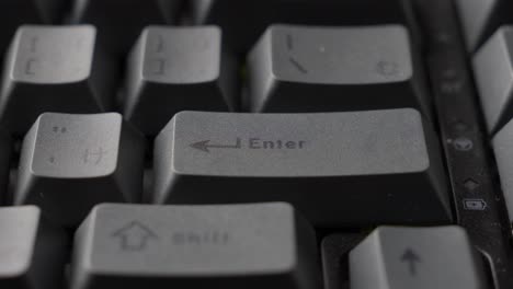 finger typing the return key of grey mechanical keyboard of computer, close up