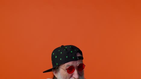 a senior man with a white beard and red sunglasses smiles at the camera