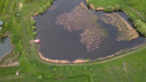 aerial view of a small dirty lake with a boat, transylvania, romania