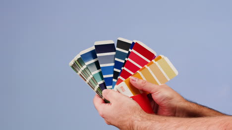 manos sosteniendo una paleta de muestras de color