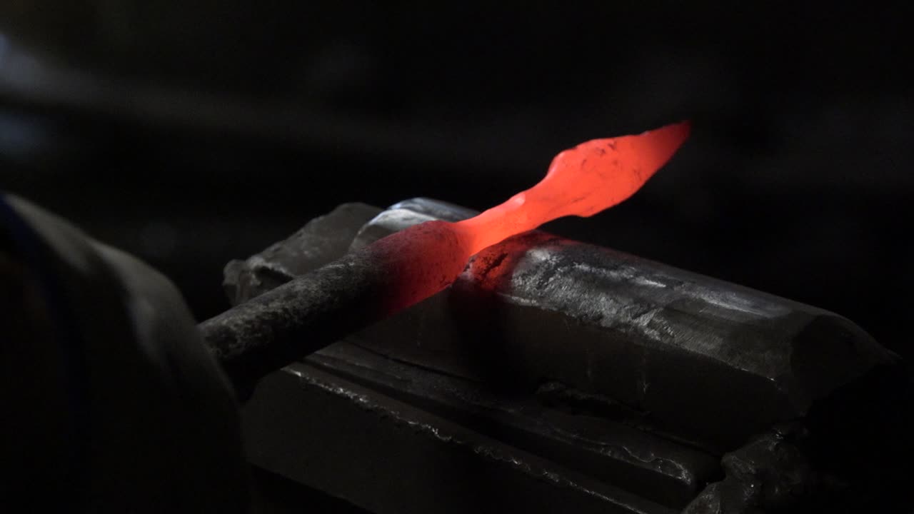 Il fabbro batte il metallo incandescente con un martello