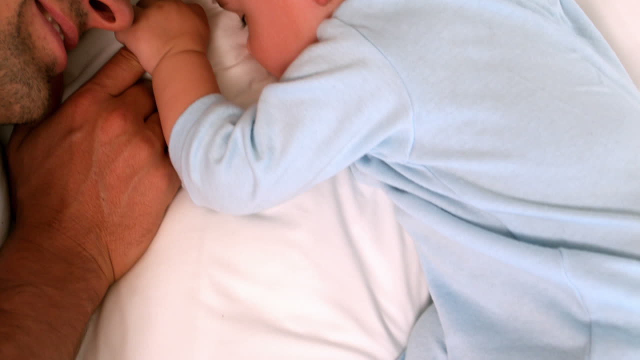 Father lying with his sleeping baby 