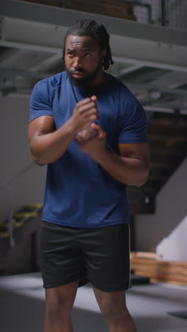 Vídeo-Vertical-De-Un-Atleta-Masculino-O-Boxeador-Entrenando-En-Un-Gimnasio-Haciendo-Sparring-Y-Calentando-Para-Prepararse-Para-Un-Evento-Deportivo-O-Una-Pelea.