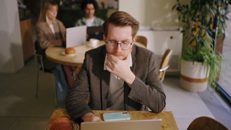 man working on his laptop in a cafe