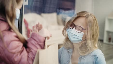 little granddaughter giving grandma shopping during quarantine