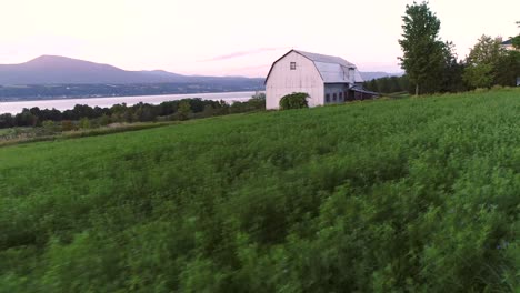 an old barn near the shore of a big river in canada