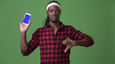 joven hombre africano guapo con dreadlocks contra un fondo verde