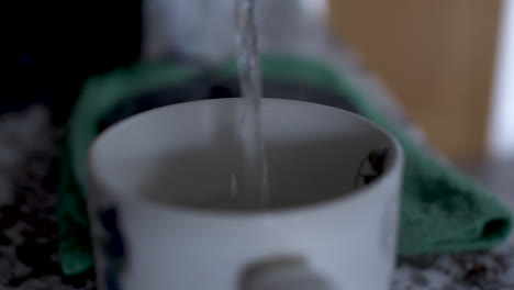 pouring water in cup for morning tea, close up static view