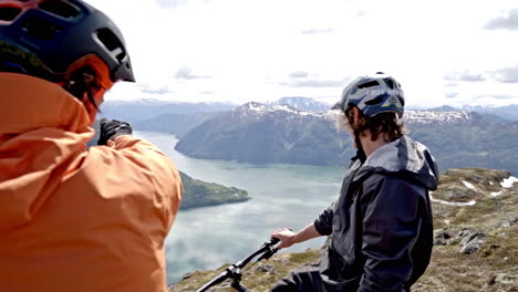 epic mountain biking adventure above the fjords near sogndal, norway. rider tackles rugged trails surrounded by dramatic cliffs, lush green hills, and stunning nordic scenery