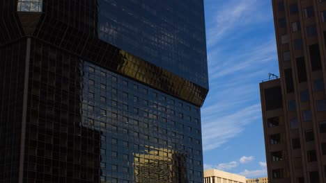 Reflejo-Del-Cielo-Azul-Con-Nubes-En-El-Exterior-De-Vidrio-De-Un-Edificio-Moderno-En-El-Centro-De-Colorado-Springs,-Colorado