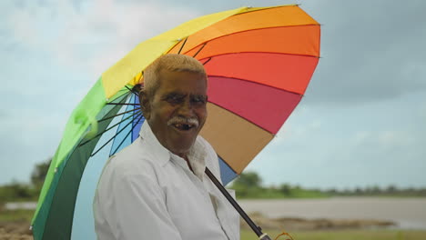 elderly man with colorful umbrella
