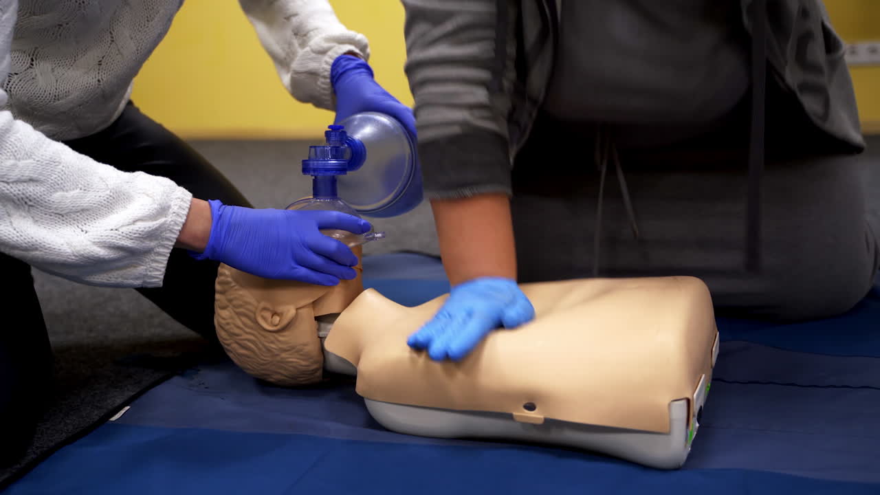 Training on a medical mannequin. People doing cardiopulmonary resuscitation. Procedure of chest compression on a dummy.