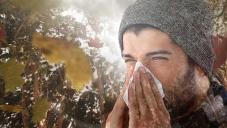 herbstblätter fallen und ein mann niest, während er an einer allergie leidet.