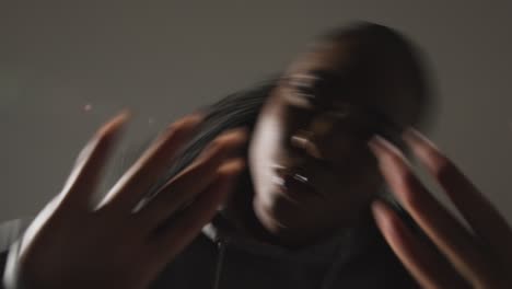 Studio-Portrait-Shot-Of-Young-Woman-Wearing-Hoodie-Dancing-With-Low-Key-Lighting-Against-Grey-Background-9