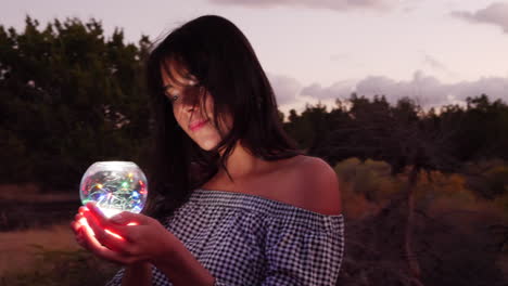 An alluring mysterious girl with a magic crystal orb glowing in an enchanted fantasy land