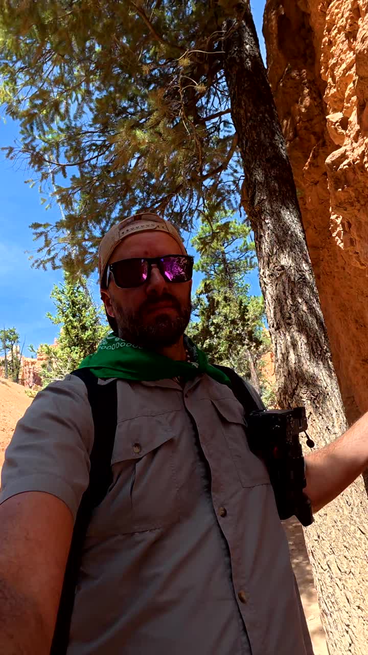 Uomo che fa escursioni e riprende in un paesaggio di canyon di roccia rossa