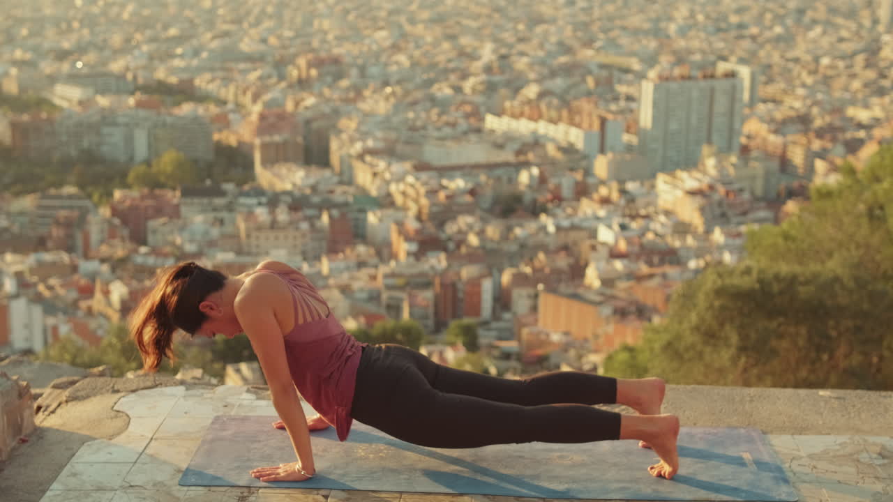 Woman doing yoga outdoors with city view