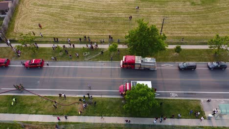 group of people gather in their neighborhood due to presence of emergency teams fire trucks