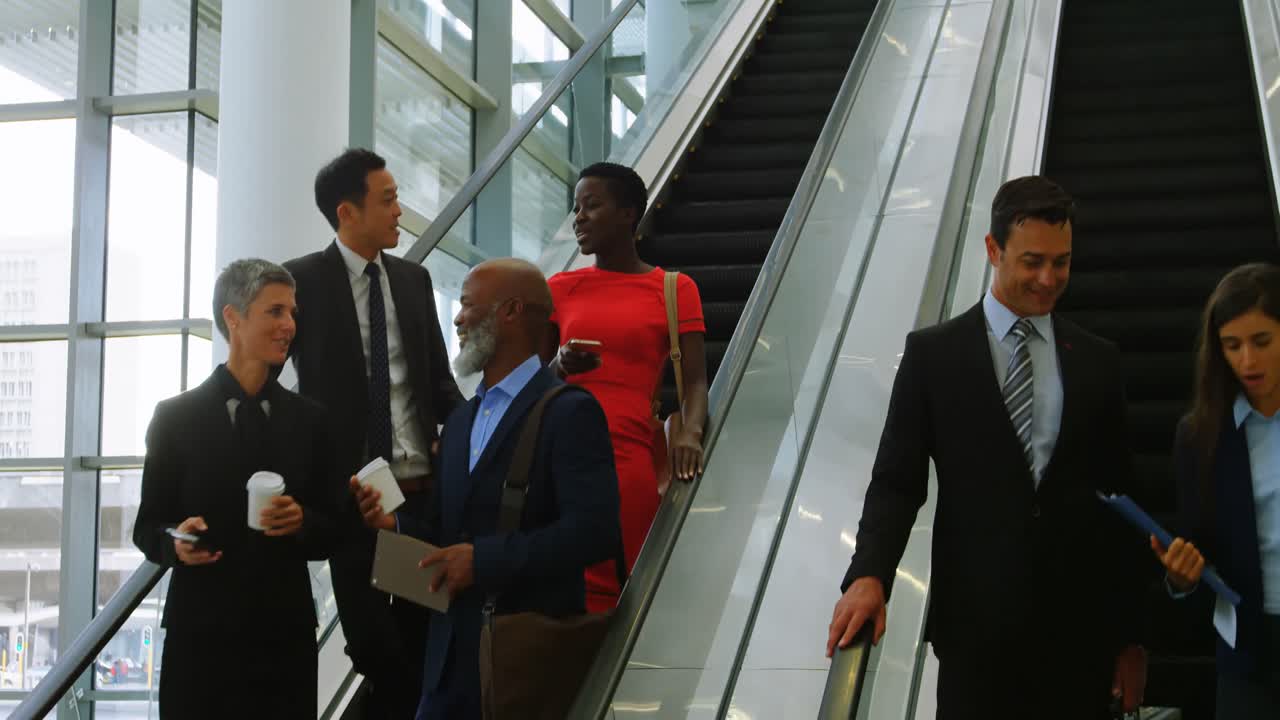 Business people talking on escalator 4k