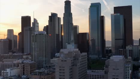 horizonte da cidade de los angeles - vista aérea ascendente com o sol poente brilhando entre edifícios