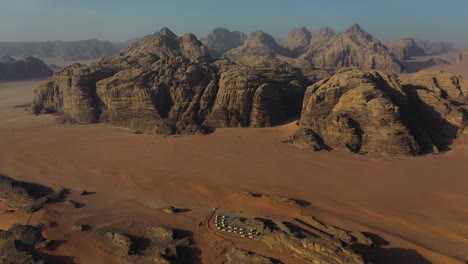 Camping-resort-in-Wadi-Rum-landscape,-Jordan,-aerial-slow-panorama