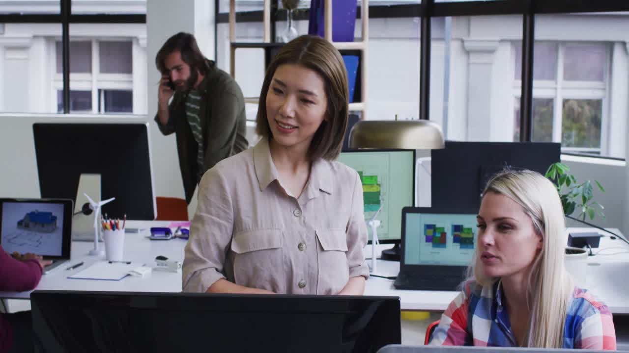 diversas personas de negocios de pie hablando usando computadora en una oficina moderna