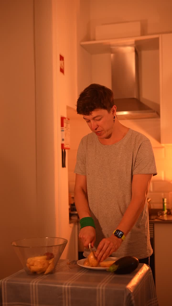 persona que cocina patatas y berenjena