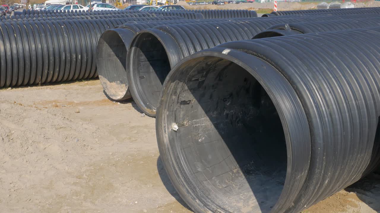 Black plastic water pipe on the ground during renovating sanitation. Big culvert for plumbing on the ground