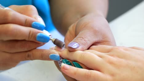 a girl has her nails polished in a beauty salon