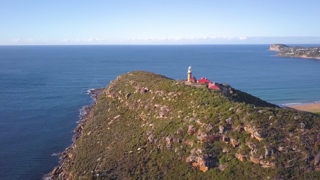 맑고 화창한 날 두 개의 해변과 바다 공중 촬영을 볼 수 있는 언덕 꼭대기 등대가 있는 아름다운 섬