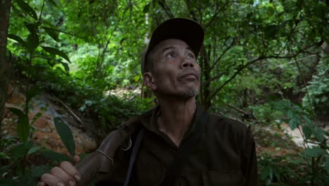 senior hunter in forest and looking around
