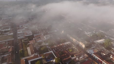 aerial view of santa catalina arch in antigua city guatemala foggy sunrise